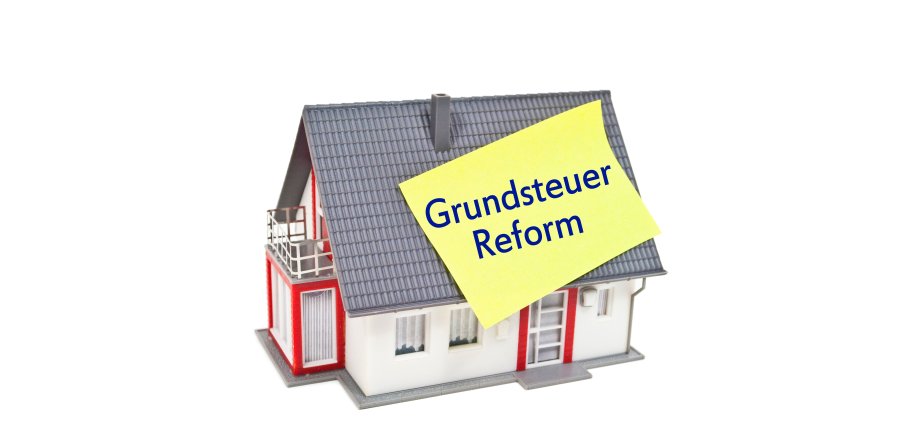 Haus mit Zettel und Grundsteuer Grundsteuerreform Haus mit Zettel und Grundsteuer Grundsteuerreform