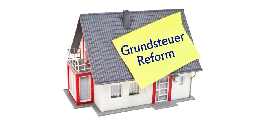 Haus mit Zettel und Grundsteuer Grundsteuerreform