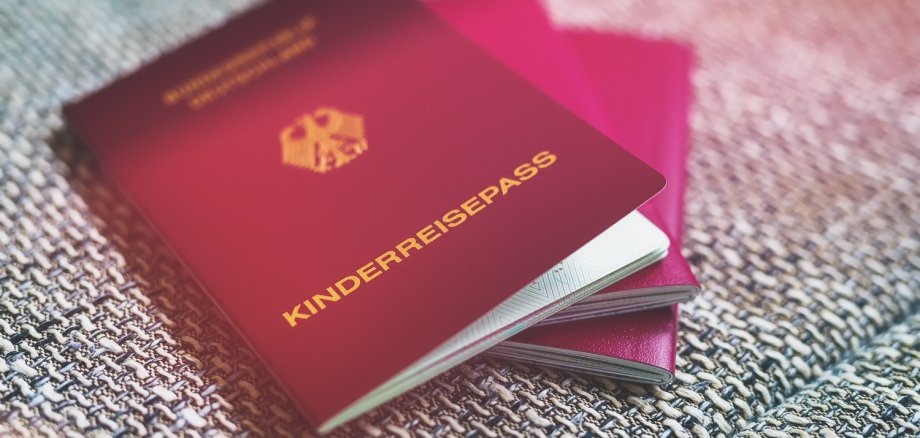 roter deutscher Kinderreisepass und andere Reisepässe liegen au